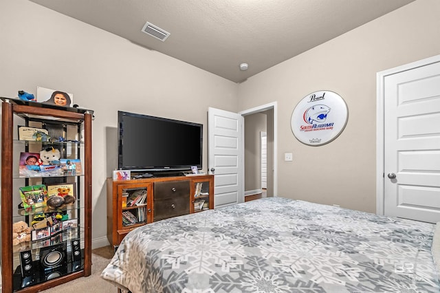 bedroom featuring a textured ceiling and carpet flooring