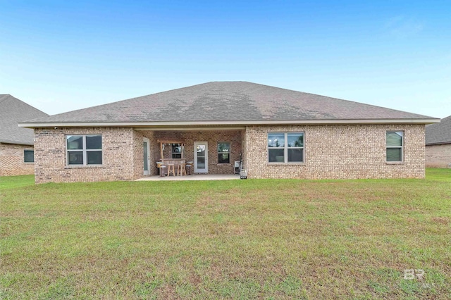 back of property with a yard and a patio