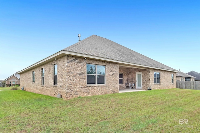 rear view of property featuring a lawn and a patio