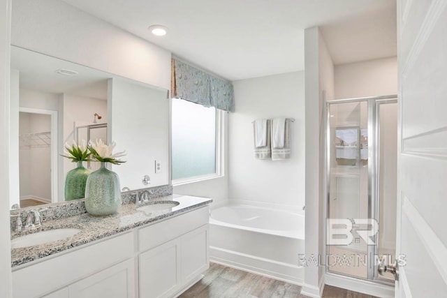 bathroom with separate shower and tub, vanity, and wood-type flooring