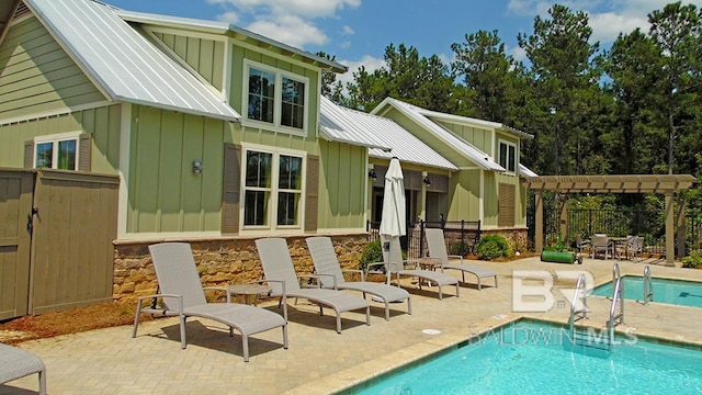 rear view of house featuring a pergola, a fenced in pool, and a patio area