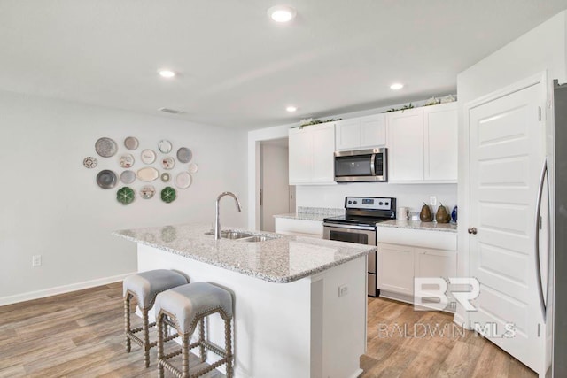 kitchen with white cabinets, sink, an island with sink, and appliances with stainless steel finishes