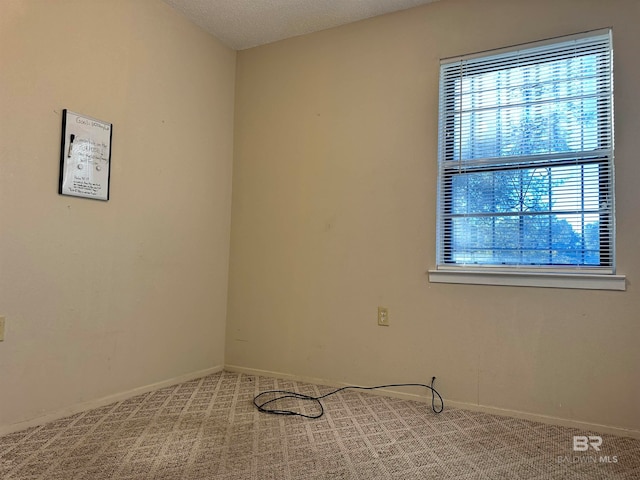 carpeted spare room with a textured ceiling