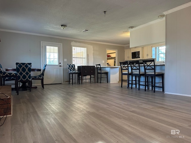 living room featuring hardwood / wood-style flooring, crown molding, and a textured ceiling