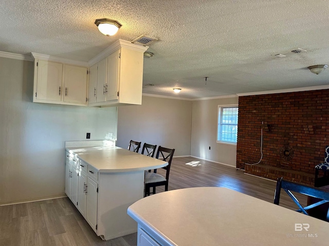 kitchen featuring white cabinetry, light hardwood / wood-style flooring, and ornamental molding