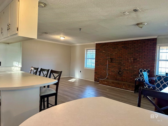 dining space featuring crown molding, dark wood-type flooring, and a textured ceiling