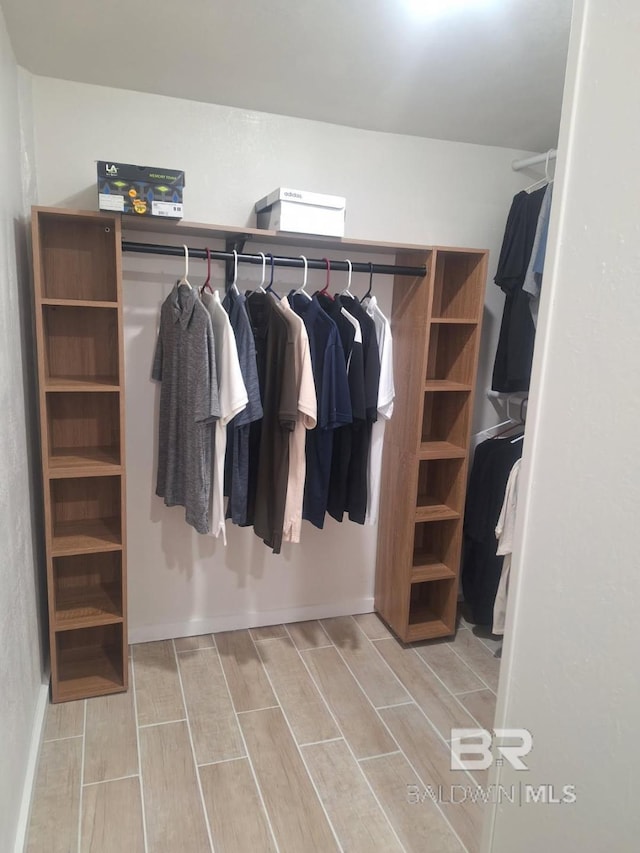 walk in closet with wood tiled floor
