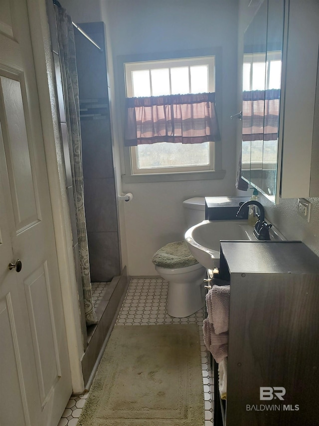 bathroom featuring vanity, tile patterned flooring, a shower stall, and toilet