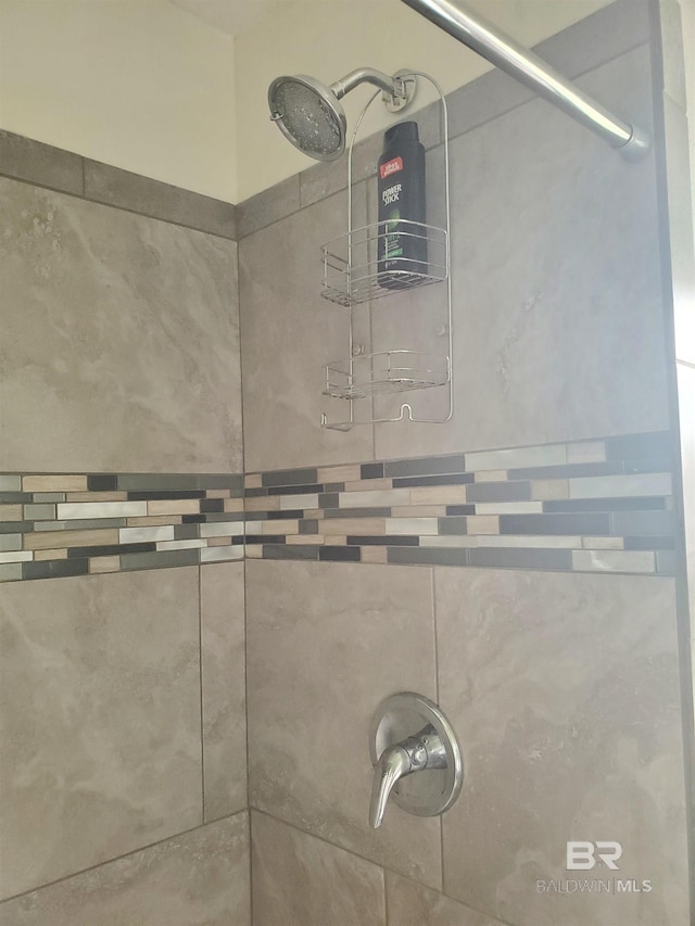interior details featuring a tile shower