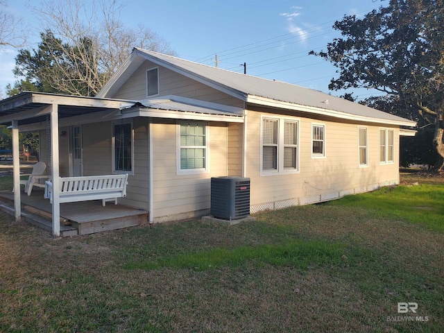 view of home's exterior with metal roof, a yard, covered porch, and cooling unit