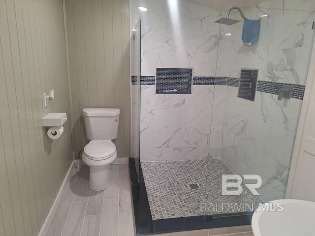 bathroom featuring a marble finish shower and toilet