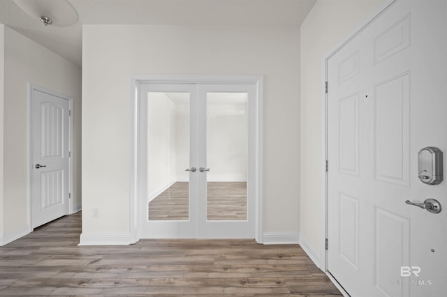interior space featuring wood finished floors, baseboards, and french doors