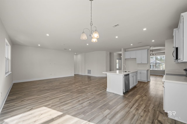 kitchen featuring stainless steel dishwasher, a notable chandelier, open floor plan, and a sink