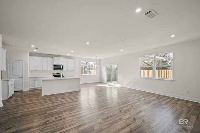 unfurnished living room featuring visible vents, recessed lighting, and wood finished floors