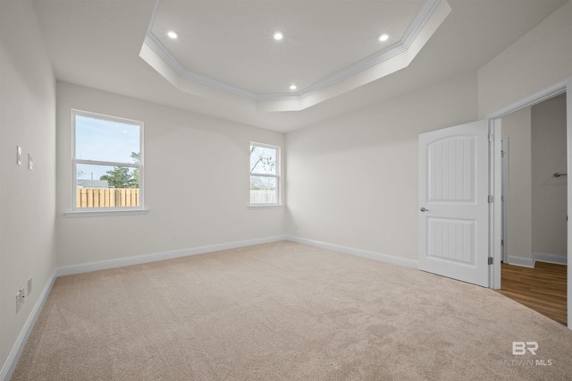 unfurnished room featuring recessed lighting, a tray ceiling, carpet floors, and crown molding