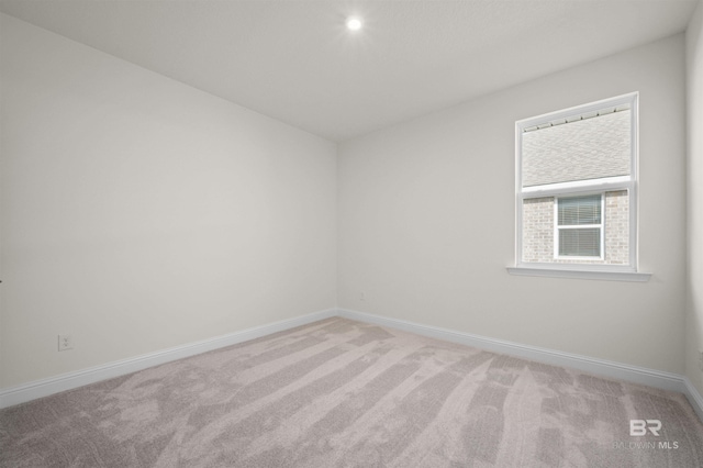 carpeted spare room with baseboards