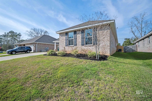 view of front facade with fence, driveway, an attached garage, a front lawn, and brick siding