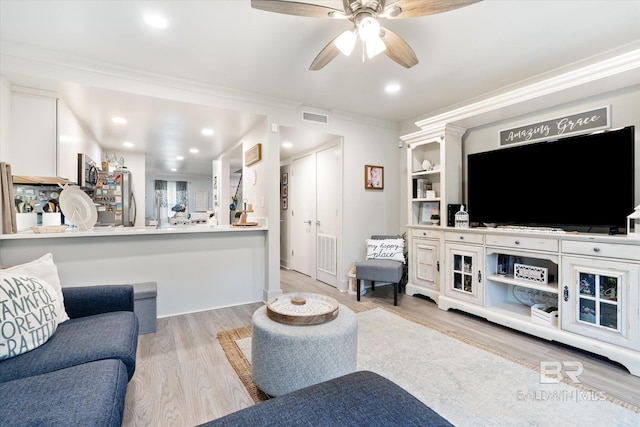 living room with ceiling fan, light hardwood / wood-style floors, and ornamental molding