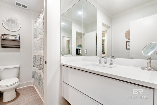 bathroom featuring ornamental molding, vanity, toilet, and hardwood / wood-style flooring