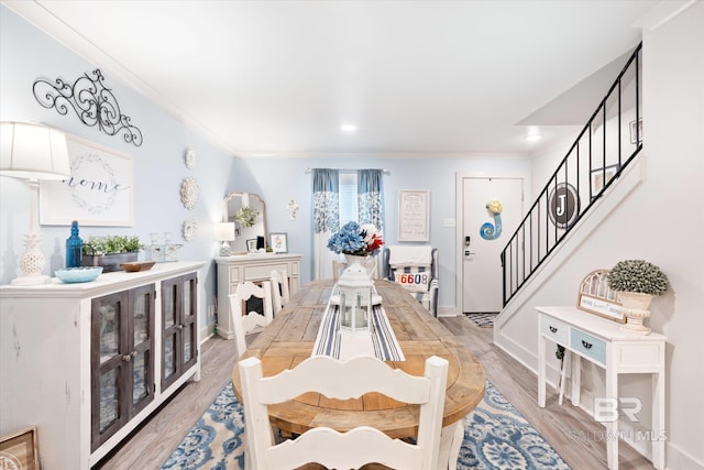 dining space featuring hardwood / wood-style floors and crown molding