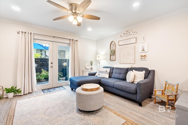 living room with ceiling fan, light hardwood / wood-style flooring, french doors, and ornamental molding