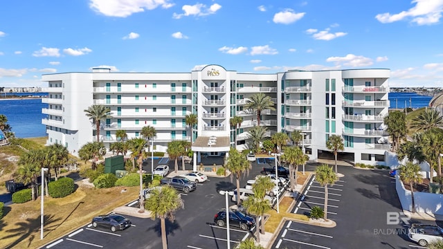 view of property with a water view and uncovered parking