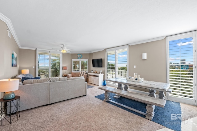 living room with ceiling fan, visible vents, carpet floors, and ornamental molding