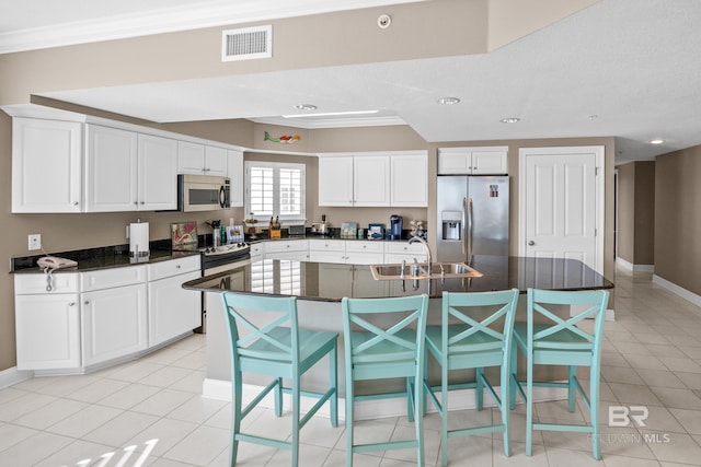 kitchen with visible vents, light tile patterned flooring, a sink, appliances with stainless steel finishes, and white cabinetry