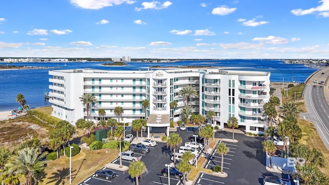 view of building exterior featuring uncovered parking and a water view