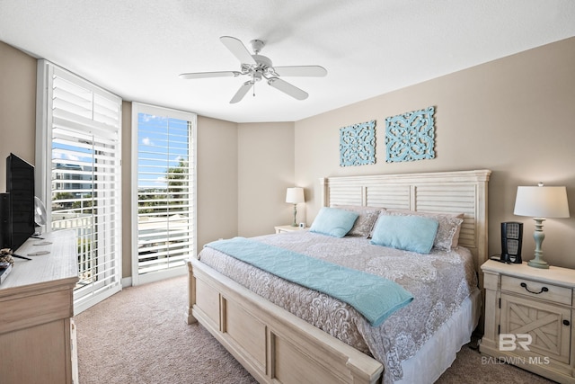 carpeted bedroom featuring access to exterior and a ceiling fan