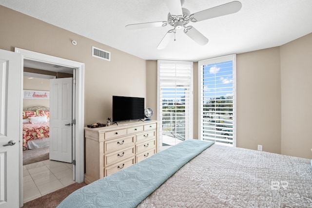 carpeted bedroom featuring expansive windows, visible vents, and ceiling fan