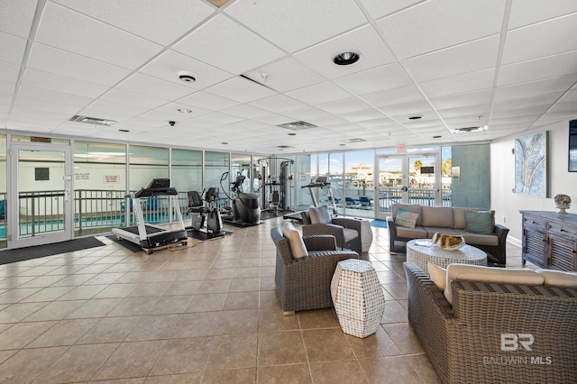 interior space featuring visible vents, a paneled ceiling, floor to ceiling windows, and tile patterned flooring