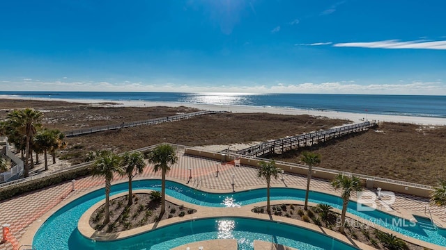 view of pool featuring a view of the beach, a jacuzzi, and a water view