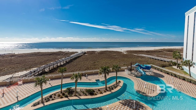 exterior space featuring a water view, fence, and a view of the beach