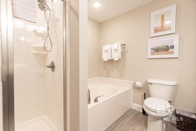 bathroom featuring a bath, baseboards, wood finish floors, a shower stall, and toilet