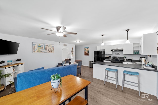 dining area featuring ceiling fan, hardwood / wood-style floors, and sink