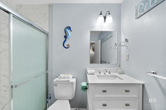 bathroom featuring vanity, a shower with shower door, and toilet