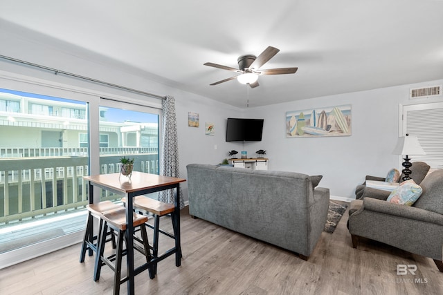 living room featuring ceiling fan and light hardwood / wood-style floors