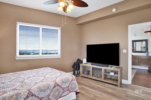 bedroom featuring wood finished floors, a ceiling fan, and baseboards