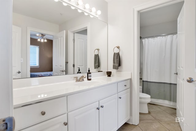 ensuite bathroom with tile patterned flooring, ensuite bath, vanity, and toilet