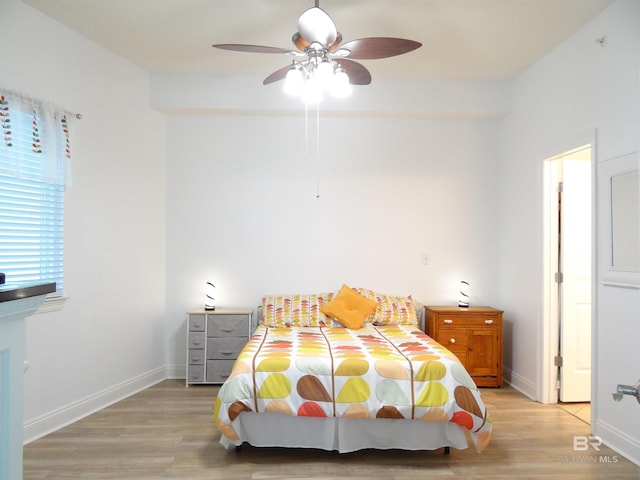 bedroom with baseboards, ceiling fan, and light wood finished floors