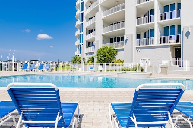 community pool with fence and a patio