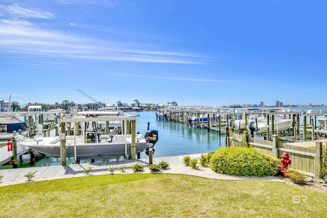 view of dock with a water view, a lawn, and boat lift