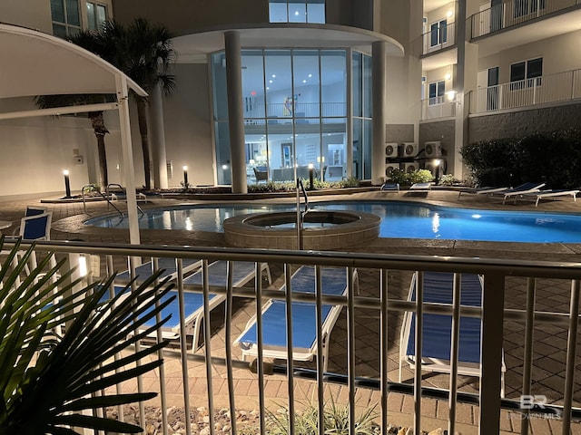 view of swimming pool with a community hot tub