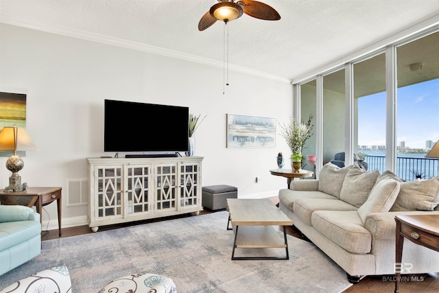 living room with a textured ceiling, wood finished floors, visible vents, baseboards, and expansive windows