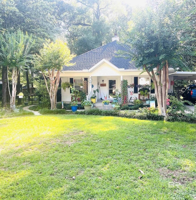 12173 Twin Oaks Dr, Magnolia Springs, AL 36555 - view of front of property featuring covered porch, a front lawn, a carport, a chimney, and roof with shingles