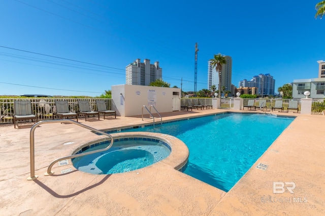 view of pool with a hot tub and a patio area