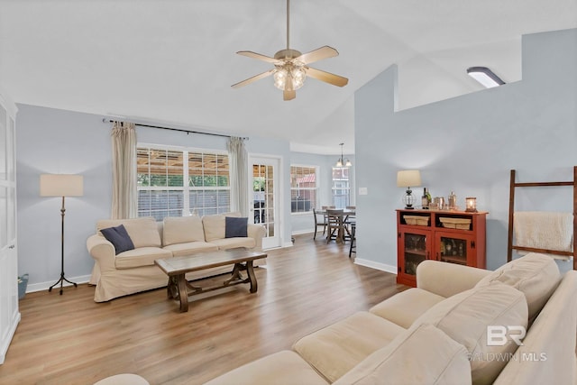 living room with baseboards, a ceiling fan, wood finished floors, and a wealth of natural light