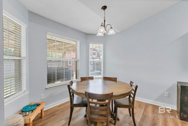 dining room with baseboards, a chandelier, and wood finished floors