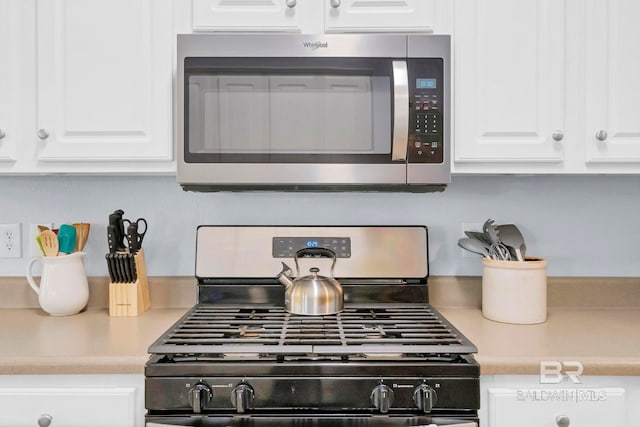 kitchen with light countertops, appliances with stainless steel finishes, and white cabinets